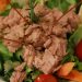 Close-up of a fresh tuna salad with vegetables and lemon garnish.